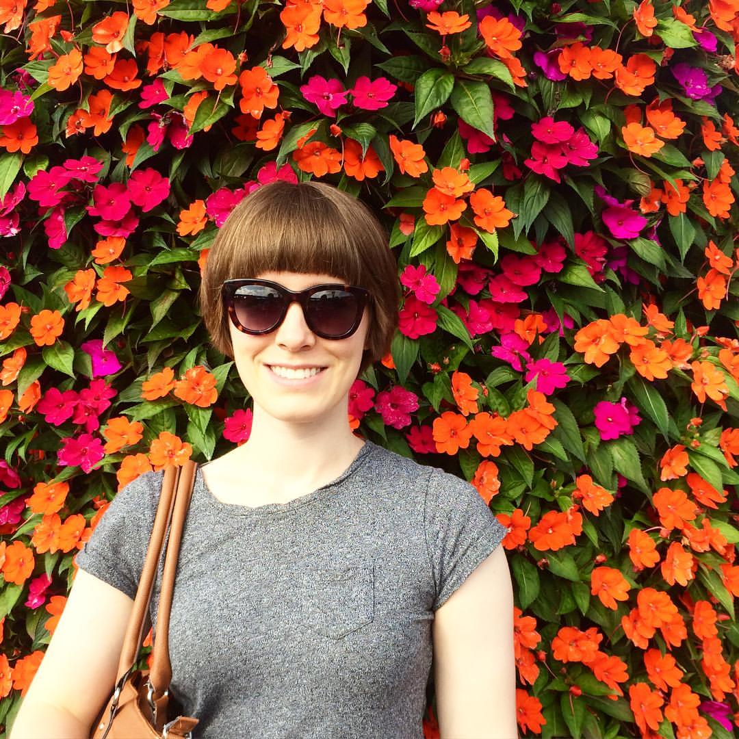 Chelsea in front of flower wall