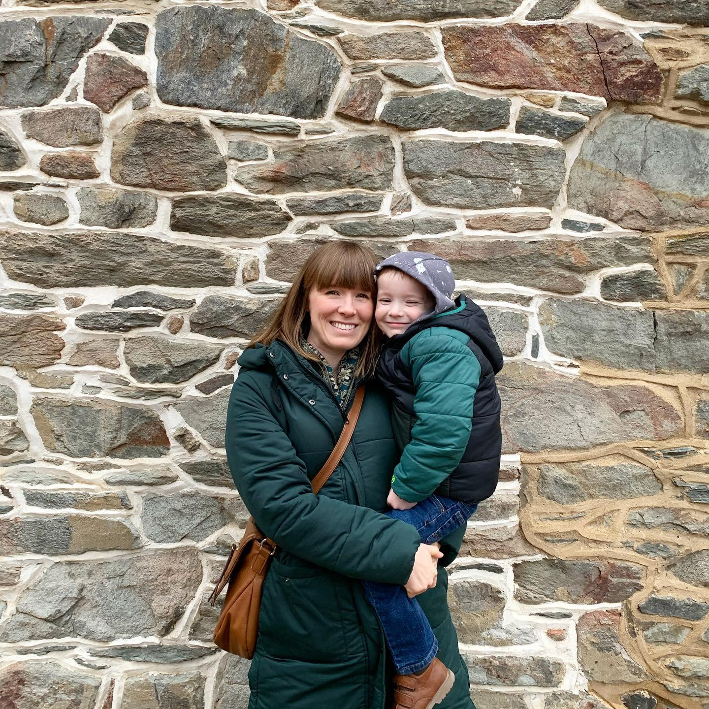 Chelsea and son in front of brick wall